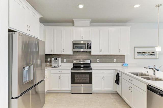 kitchen featuring backsplash, light tile patterned flooring, appliances with stainless steel finishes, and a sink