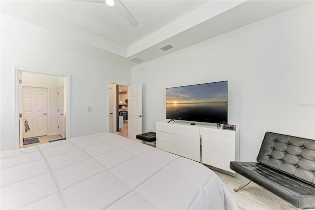 bedroom with a tray ceiling, visible vents, and ceiling fan