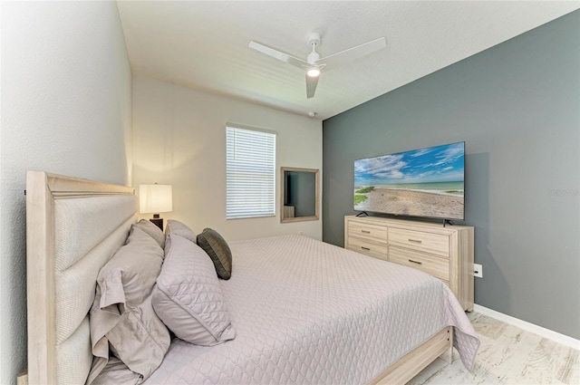 bedroom with a ceiling fan, light wood-type flooring, and baseboards