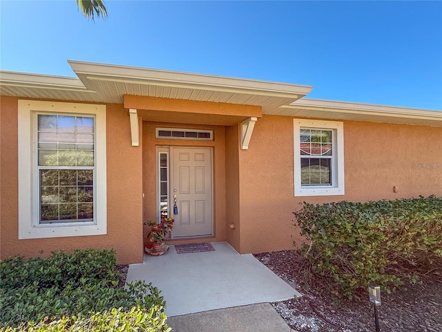 entrance to property featuring stucco siding