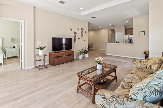 living area with recessed lighting, visible vents, arched walkways, and light wood-style floors