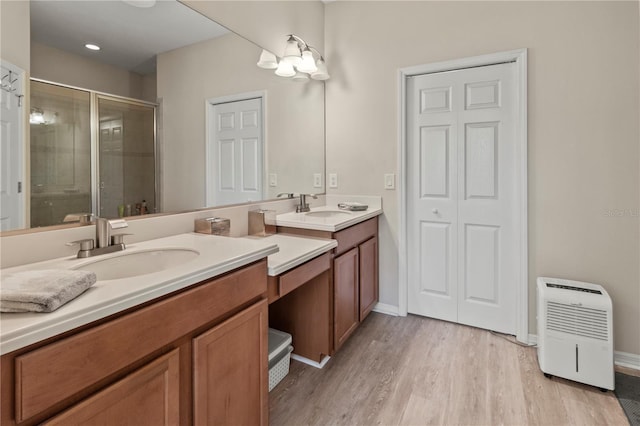 full bath featuring vanity, a shower stall, wood finished floors, and baseboards