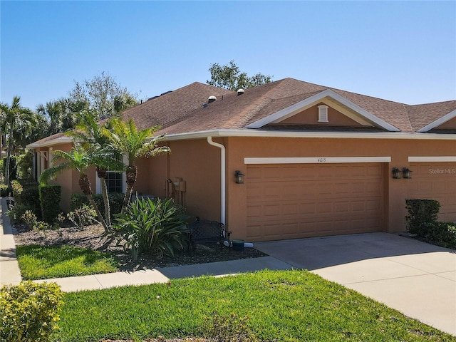 view of front facade featuring stucco siding, driveway, an attached garage, and roof with shingles