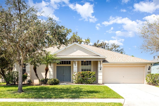 view of front facade with a front yard, driveway, and stucco siding