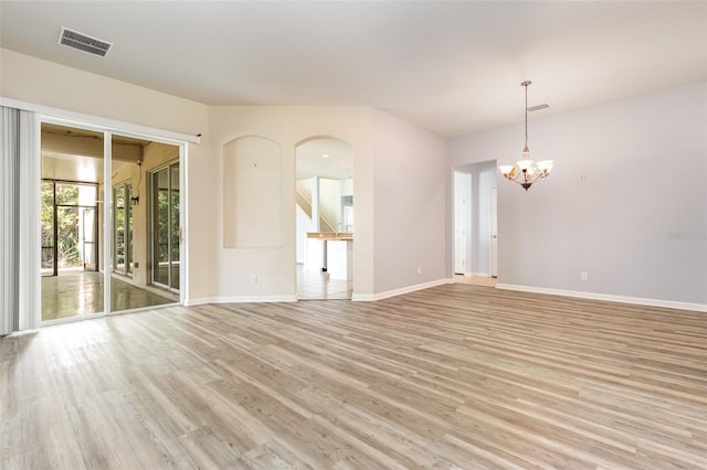 unfurnished room featuring an inviting chandelier, baseboards, visible vents, and light wood-type flooring