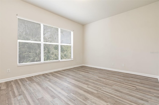 unfurnished room with baseboards and wood finished floors