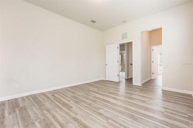 unfurnished room with light wood-style flooring, baseboards, and visible vents