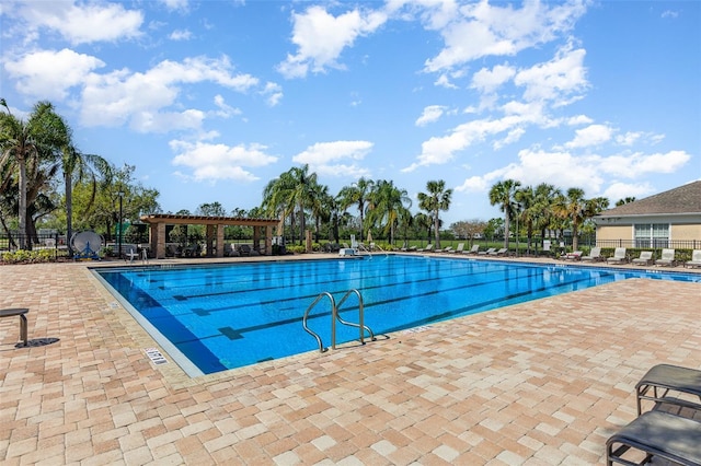 community pool with a patio and fence