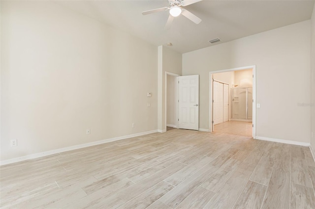 empty room with visible vents, baseboards, light wood-style floors, and a ceiling fan