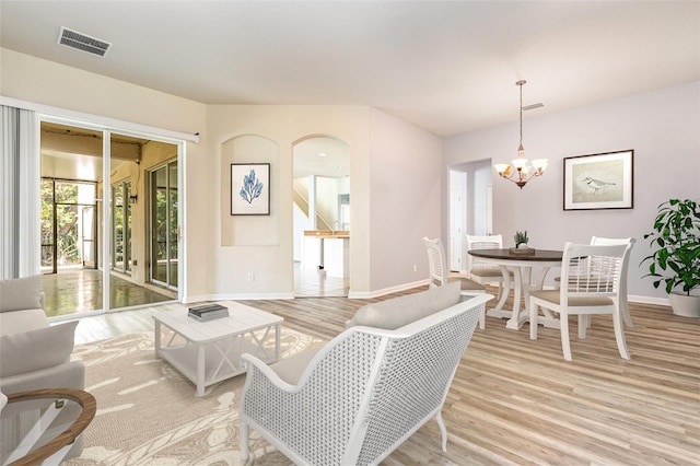 living room with a chandelier, visible vents, light wood-type flooring, and baseboards