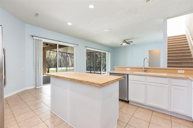 kitchen featuring dishwasher, white cabinets, ceiling fan, and a sink