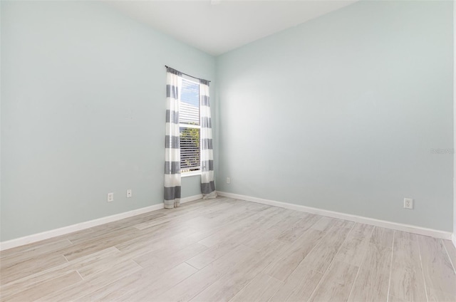 empty room with baseboards and light wood-style floors