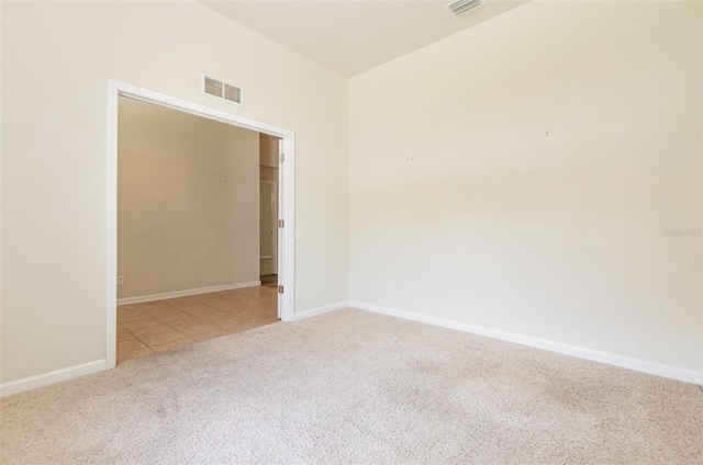 spare room featuring visible vents, baseboards, and carpet