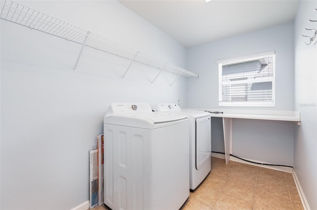 laundry room with light tile patterned floors, laundry area, washer and dryer, and baseboards