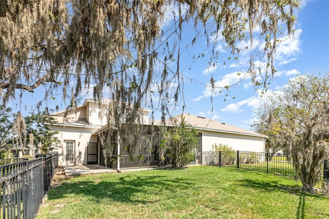 view of yard with a fenced backyard and a sunroom