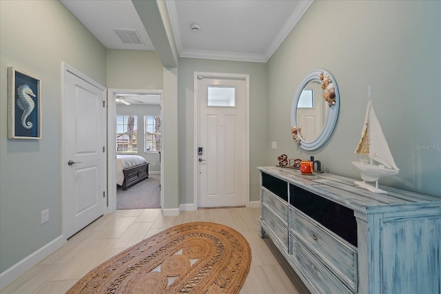 foyer featuring crown molding, light tile patterned floors, baseboards, and visible vents