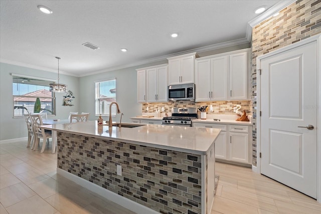 kitchen with tasteful backsplash, visible vents, light countertops, appliances with stainless steel finishes, and a sink