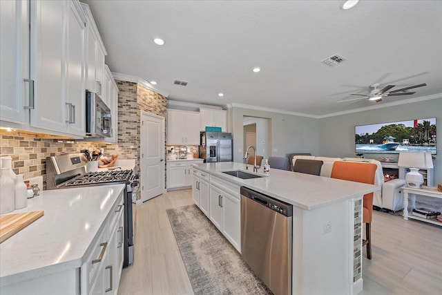 kitchen featuring a sink, stainless steel appliances, visible vents, and open floor plan