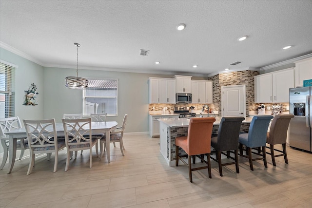 dining space with visible vents, a textured ceiling, and crown molding