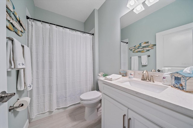 full bath featuring a shower with shower curtain, toilet, and vanity