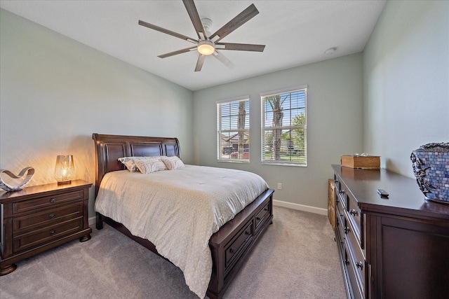 bedroom with light colored carpet, a ceiling fan, and baseboards