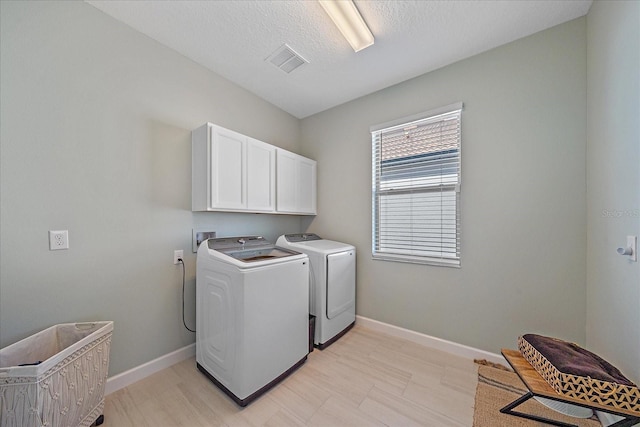 laundry area with visible vents, baseboards, washer and clothes dryer, cabinet space, and a textured ceiling