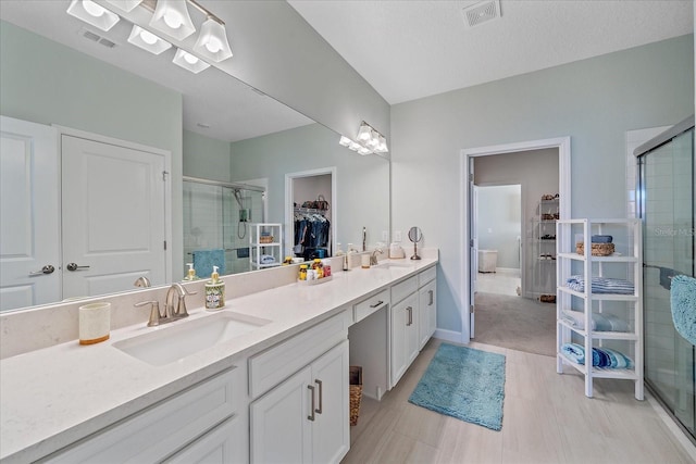 full bath with a shower stall, visible vents, and a sink