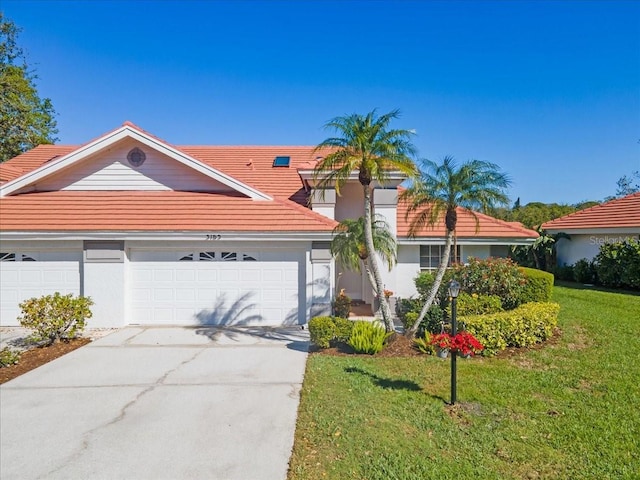 view of front of home featuring stucco siding, driveway, a front lawn, and an attached garage