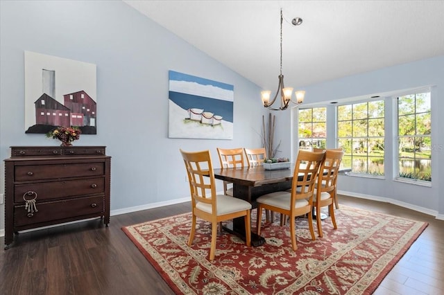 dining room featuring dark wood finished floors, vaulted ceiling, baseboards, and a chandelier