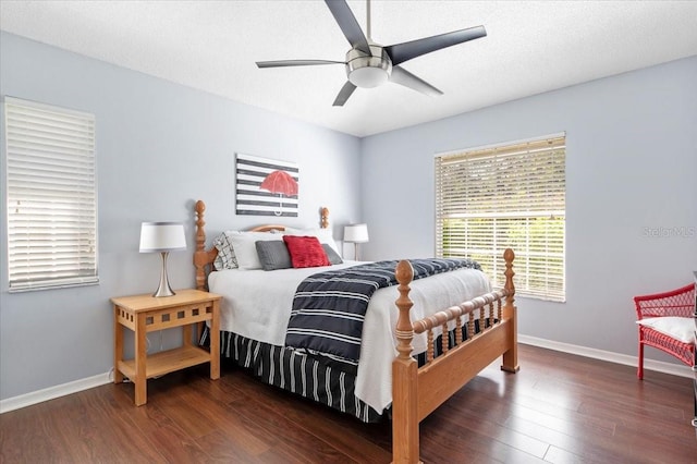 bedroom featuring a textured ceiling, baseboards, and wood finished floors