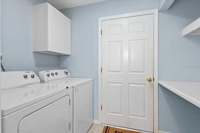 washroom with washer and dryer, baseboards, and cabinet space