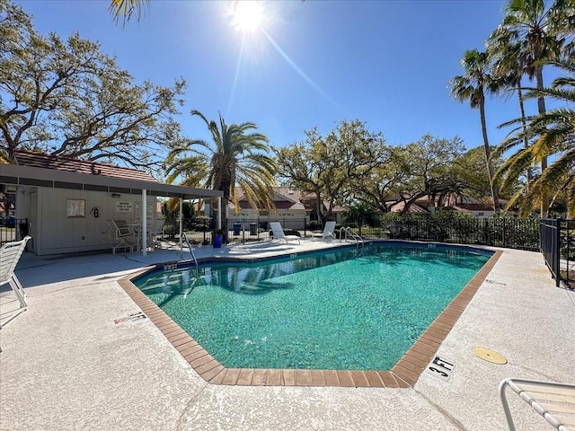 pool with a patio and fence