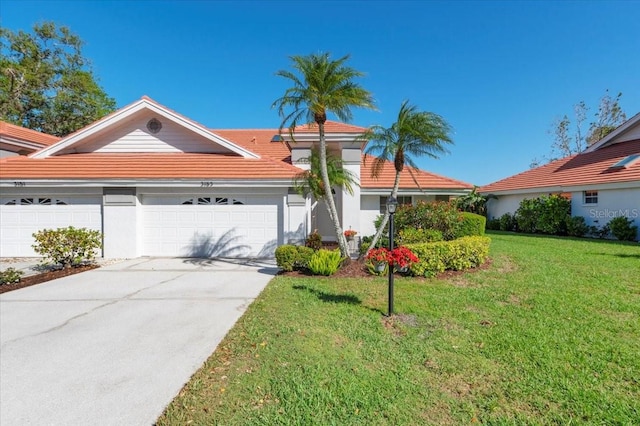 view of front facade featuring driveway, stucco siding, a front lawn, a garage, and a tiled roof