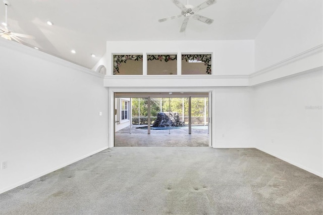 unfurnished room with a high ceiling, a ceiling fan, baseboards, and carpet floors