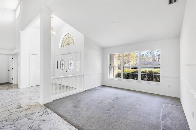 foyer with visible vents, baseboards, high vaulted ceiling, and marble finish floor