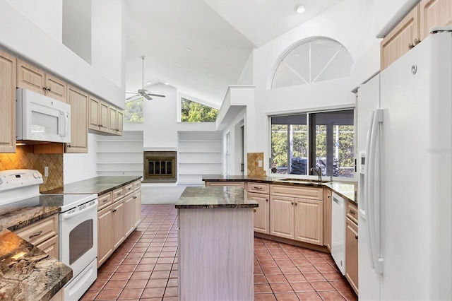 kitchen featuring white appliances, light tile patterned floors, high vaulted ceiling, ceiling fan, and a center island