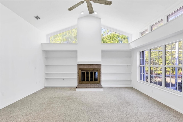 unfurnished living room with a brick fireplace, built in shelves, visible vents, and a wealth of natural light