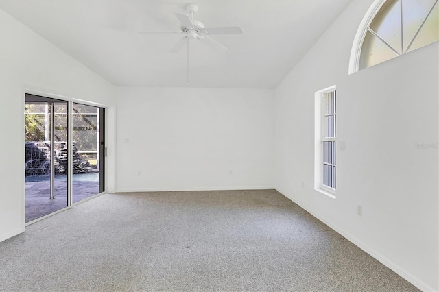 carpeted spare room with high vaulted ceiling, baseboards, and ceiling fan