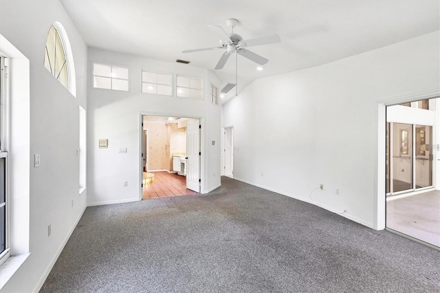 spare room featuring visible vents, a ceiling fan, carpet flooring, baseboards, and a towering ceiling