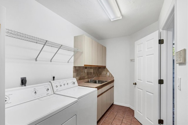 clothes washing area featuring washer and dryer, light tile patterned flooring, cabinet space, and a sink