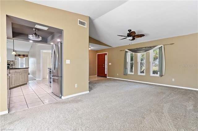unfurnished living room with visible vents, ceiling fan, baseboards, vaulted ceiling, and light carpet
