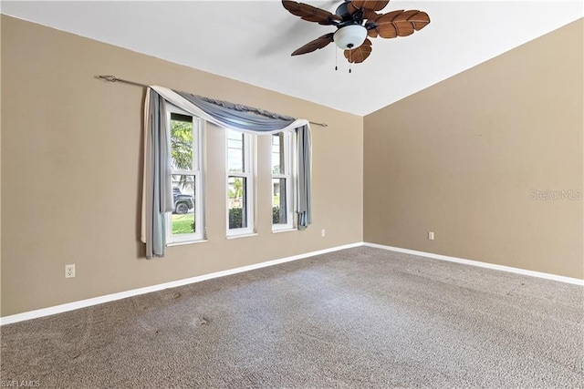 carpeted empty room with a ceiling fan and baseboards