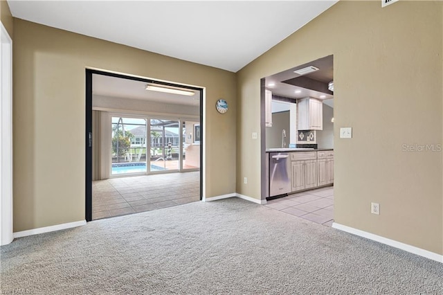 interior space featuring light colored carpet, light tile patterned flooring, and baseboards