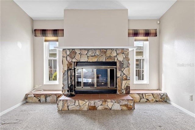 room details featuring baseboards, carpet floors, and a stone fireplace