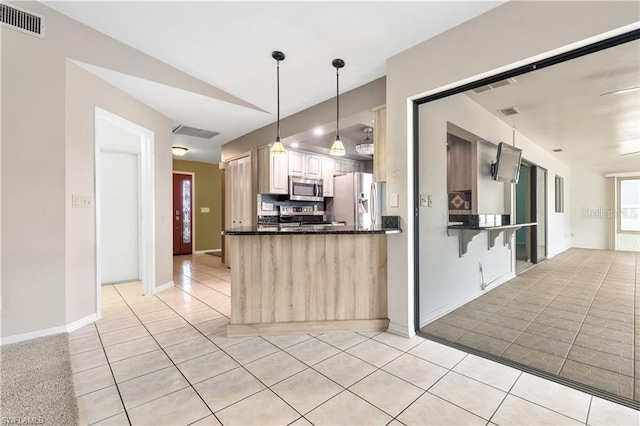 kitchen featuring light tile patterned floors, visible vents, a peninsula, and stainless steel appliances