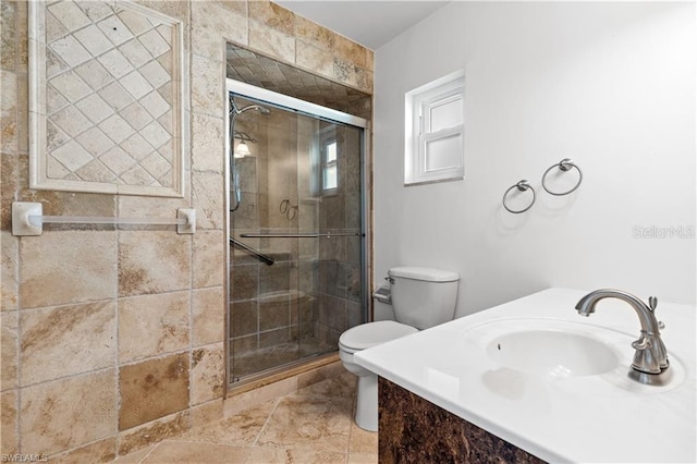 bathroom with a stall shower, toilet, and a sink