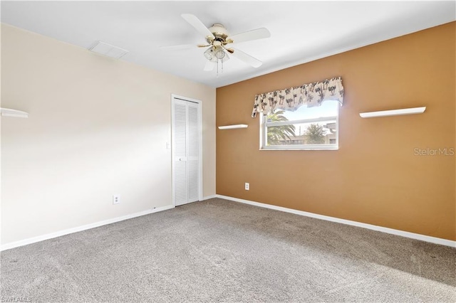 empty room featuring a ceiling fan, visible vents, carpet floors, and baseboards