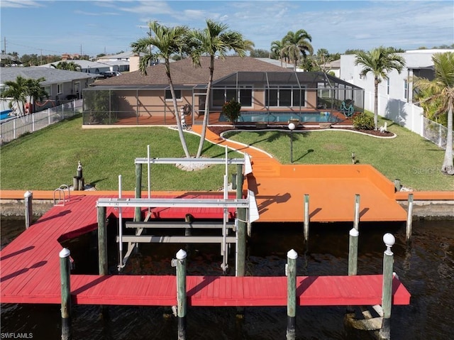 dock area with boat lift, a yard, a water view, a fenced backyard, and a swimming pool