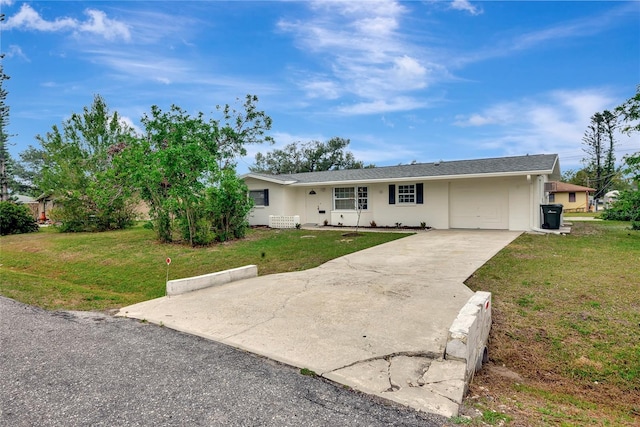 ranch-style house featuring a front lawn, concrete driveway, and stucco siding