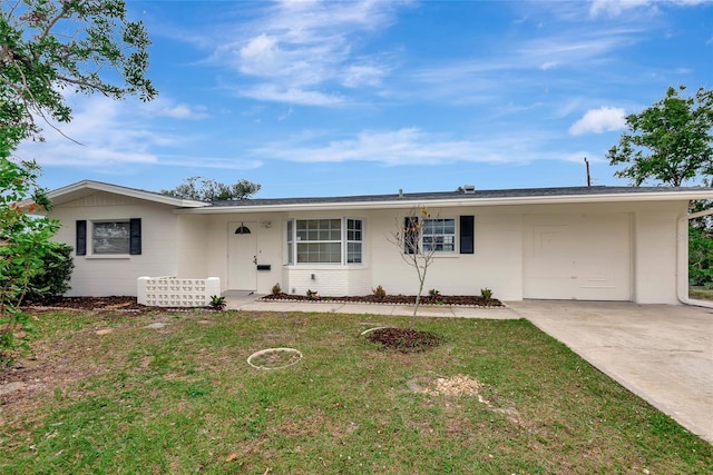 ranch-style house featuring a front yard, concrete driveway, and an attached garage